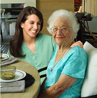 A nurse with an elderly woman, as is served by Aqua Home Care, a homecare facility specializing in elder care. Meet Aqua Home Care Today.