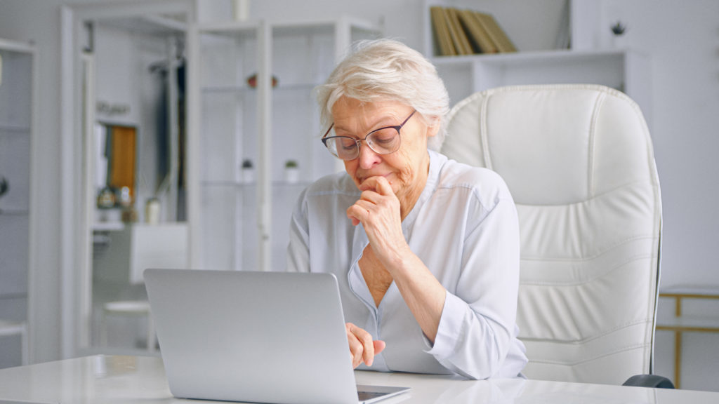 Elderly lady potentially typing a Testimonial, or reading the testimonials on her computer for Aqua Home Care