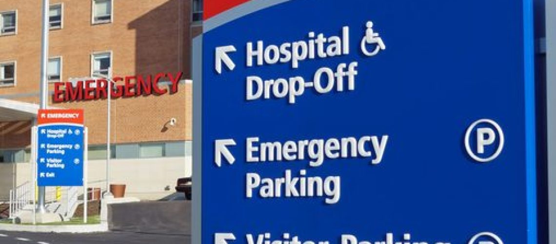 Signs outside a hospital identifying the emergency room entrance.