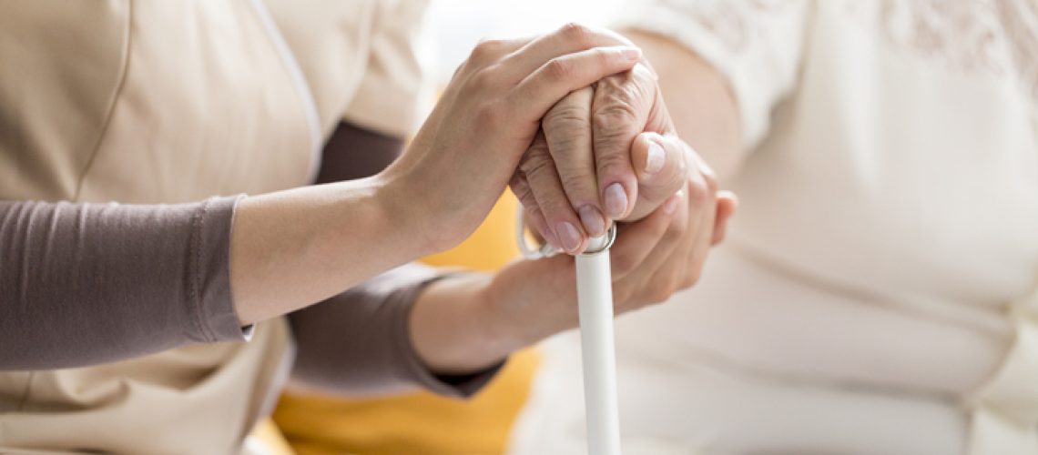Woman comforting a senior lady, holding a cane